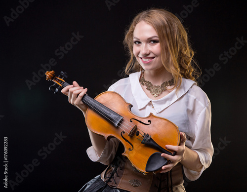 Zdjęcie XXL Uśmiechnięta młoda dziewczyna trzyma skrzypce