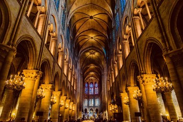 mystical image of the interior of notre dame cathedral in paris with candles of lit faithful illumin