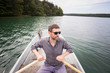 © Gonzales Photo - A man is rowing a rowboat on a lake.