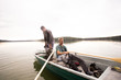 © Gonzales Photo - Two mature men are putting on waders before fly fishing from a lake.