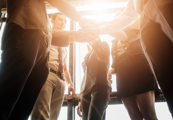 Wall Mural - overexposed tone. Business people join hand together during their meeting with sun rays aura background.