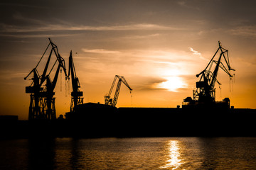 Kräne bei Sonnenuntergang im Hafen von Pula in Kroatien
