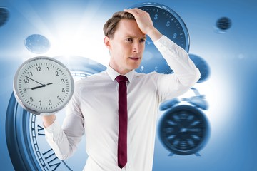 Poster - Composite image of anxious businessman holding a clock 