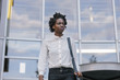 © VegterFoto/Stocksy - Black Woman leaving Office Building