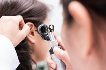 doctor examined the patient's ear with otoscope. patient seem to have problems with hearing.