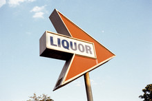 Arrow Sign Pointing Towards An Anonymous Liquor Store