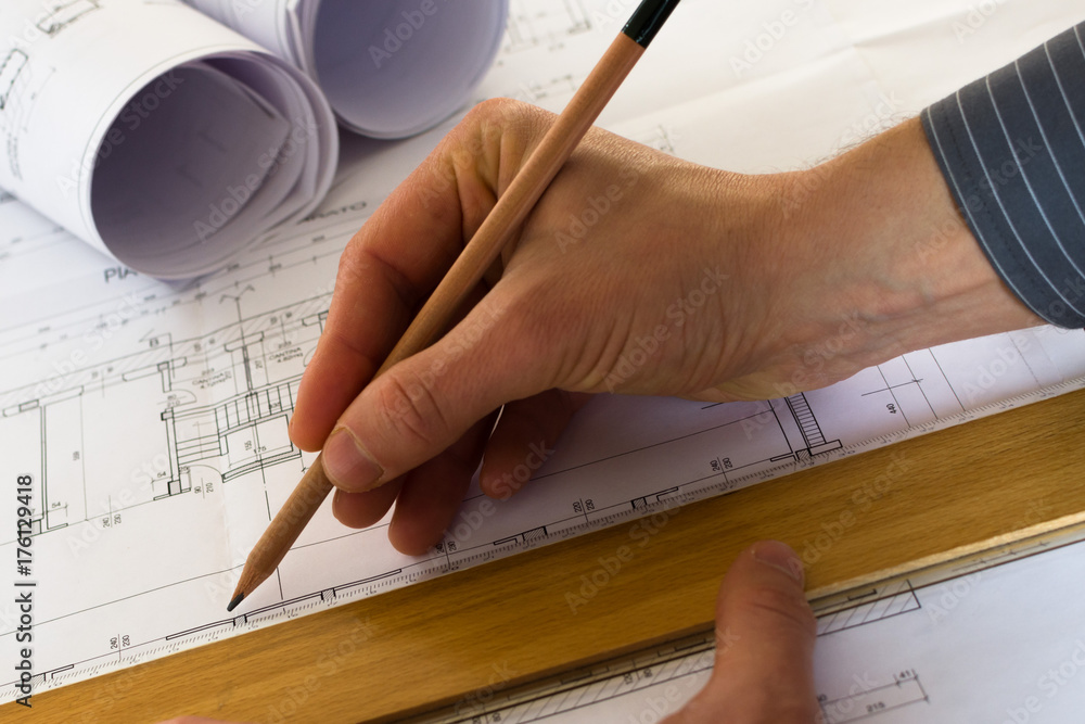 Engineer designing a house or palace. Rolls of architectural drawings ...