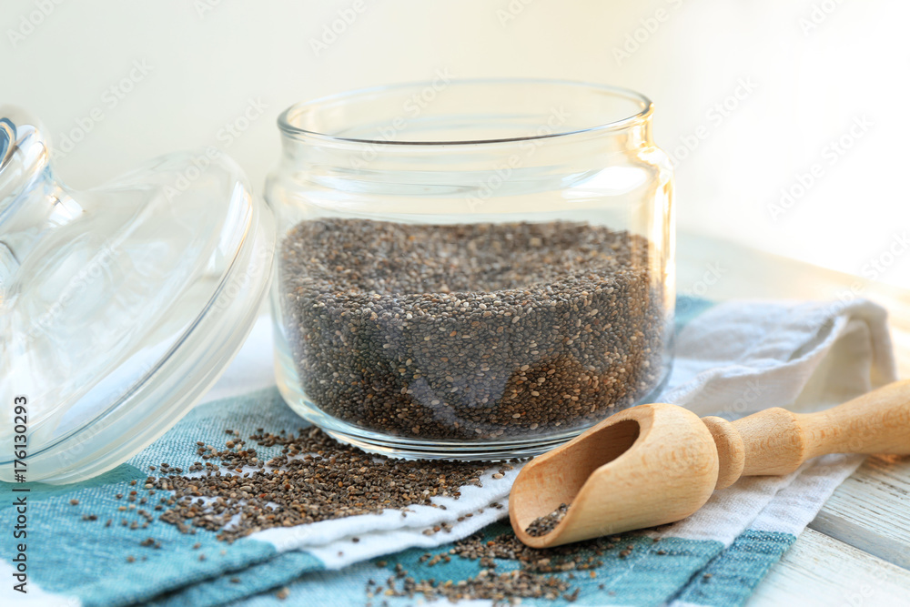 Chia seeds in jar and scoop on table