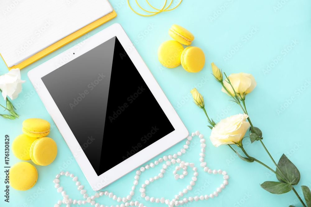 Composition with tablet, necklace, macarons and flowers on color background. Beauty blogger concept