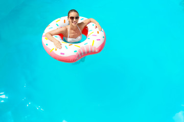 Sticker - Young woman with inflatable donut in swimming pool