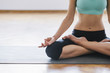 © Aleksandar Novoselski/Stocksy - Young woman meditating at home, practicing yoga