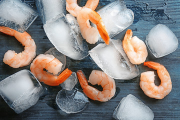 Wall Mural - Frozen shrimps with ice  on wooden board, close up