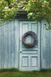 © Sandralise/Stocksy - Old blue barn door with wreath