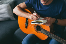 Man Composing Music With Guitar