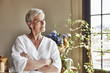 © altoimages/Stocksy - Happy Senior Woman Standing Arms Crossed At Home