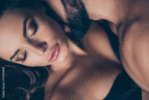 Fototapeta na szkło Zbliżenie przyciętej fotografii pięknej młodej brunetki rasy białej w seksownym czarnym staniku z zamkniętymi oczami, tak gorącej i kuszącej, atrakcyjnej i uwodzicielskiej, cieszącej się ze swoim kochankiem