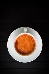 Canvas Print - top view of a half of cup of coffee. cup of coffee lies on a dark background. coffee shops concept.