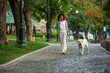 © Drobot Dean - Young busy beautiful lady walking with dog and talking on phone