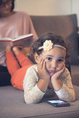 Wall Mural - Adorable thoughtful girl using mobile phone at home.