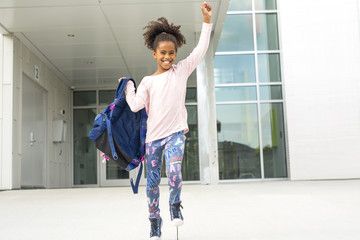 cheerful african american primary school girl with backpack