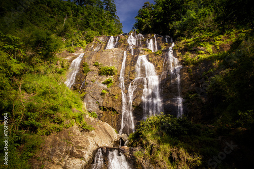 Fotografering Pictorial Waterfall on Rocks between Tropical Jungle