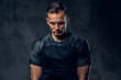 © Fxquadro - Athletic man looking down on black background