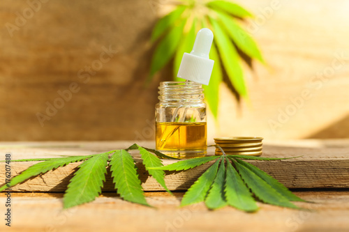 Plakat Zieleni liście lecznicza marihuana z ekstrakta olejem na drewnianym stole