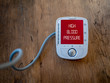 © Adam - Medical device show high blood pressure on monitor. Digital measuring of health.  Text on red varning display.