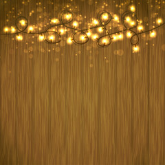 Wall Mural - Bright Christmas Light garland over wooden table