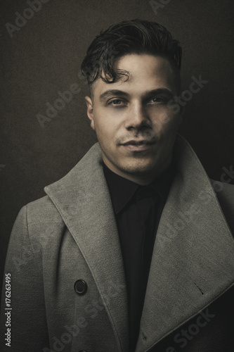 Vintage And Retro Portrait Of Illuminated Man In Grey Coat With