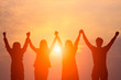 Soft focus silhouette of happy business team making high hands in sunset sky background for business teamwork concept