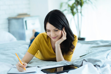 Pretty brunette preparing for exams with tablet computer