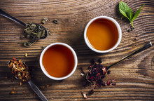 Two Cups Of Loose Leaf Tea On A Wooden Table, Top View