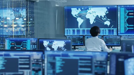 Fototapete - In the System Control Room Operator Sits at His Workstation with Multiple Displays Showing Graphics and Logistics Information. Shot on RED EPIC-W 8K Helium Cinema Camera.