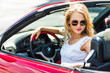 © speed300 - Beautiful blonde girl in a convertible red car. Sunny day