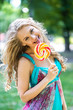 © speed300 - Attractive blond girl with a lollipop in the park in summer
