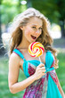 © speed300 - Attractive blond girl with a lollipop in the park in summer