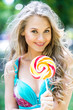 © speed300 - Attractive blond girl with a lollipop in the park in summer