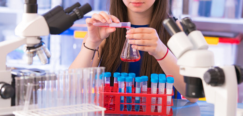 Wall Mural - A teenage girl in a school laboratory in chemistry and biology classes