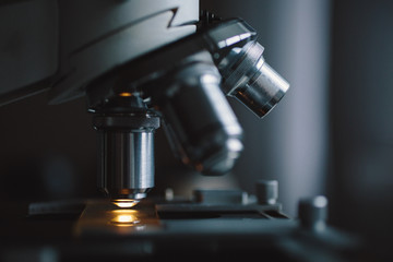 Wall Mural - close-up shot of microscope with metal lens at laboratory.