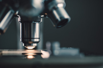 Close-up shot of microscope with metal lens at laboratory.