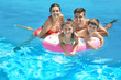 © Africa Studio - Happy family with inflatable ring relaxing in swimming pool