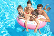 © Africa Studio - Happy family with inflatable ring relaxing in swimming pool
