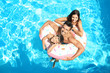 © Africa Studio - Young couple and cute son with inflatable ring in pool