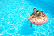 © Africa Studio - Happy family with inflatable ring relaxing in swimming pool