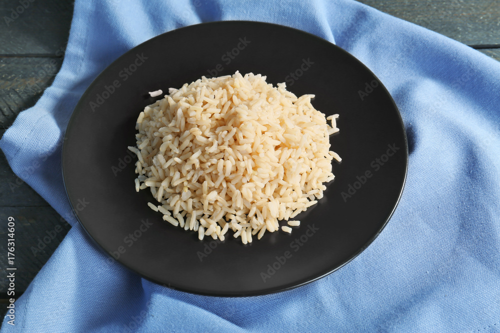Plate with cooked rice on table