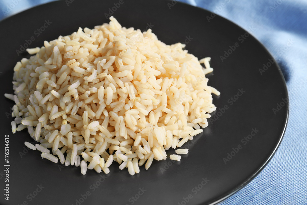 Plate with cooked rice on table