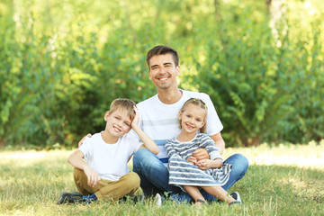 Canvas Print - Father with children in park on sunny day