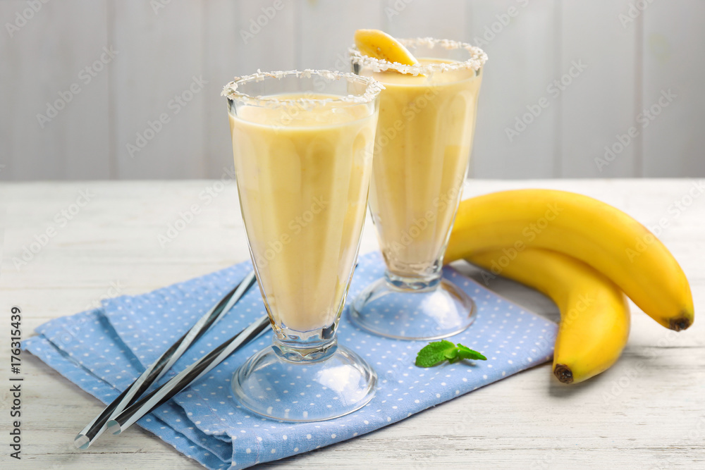 Glasses with tasty banana smoothie on table