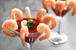 Glass with shrimp cocktail and tomato sauce on table, closeup